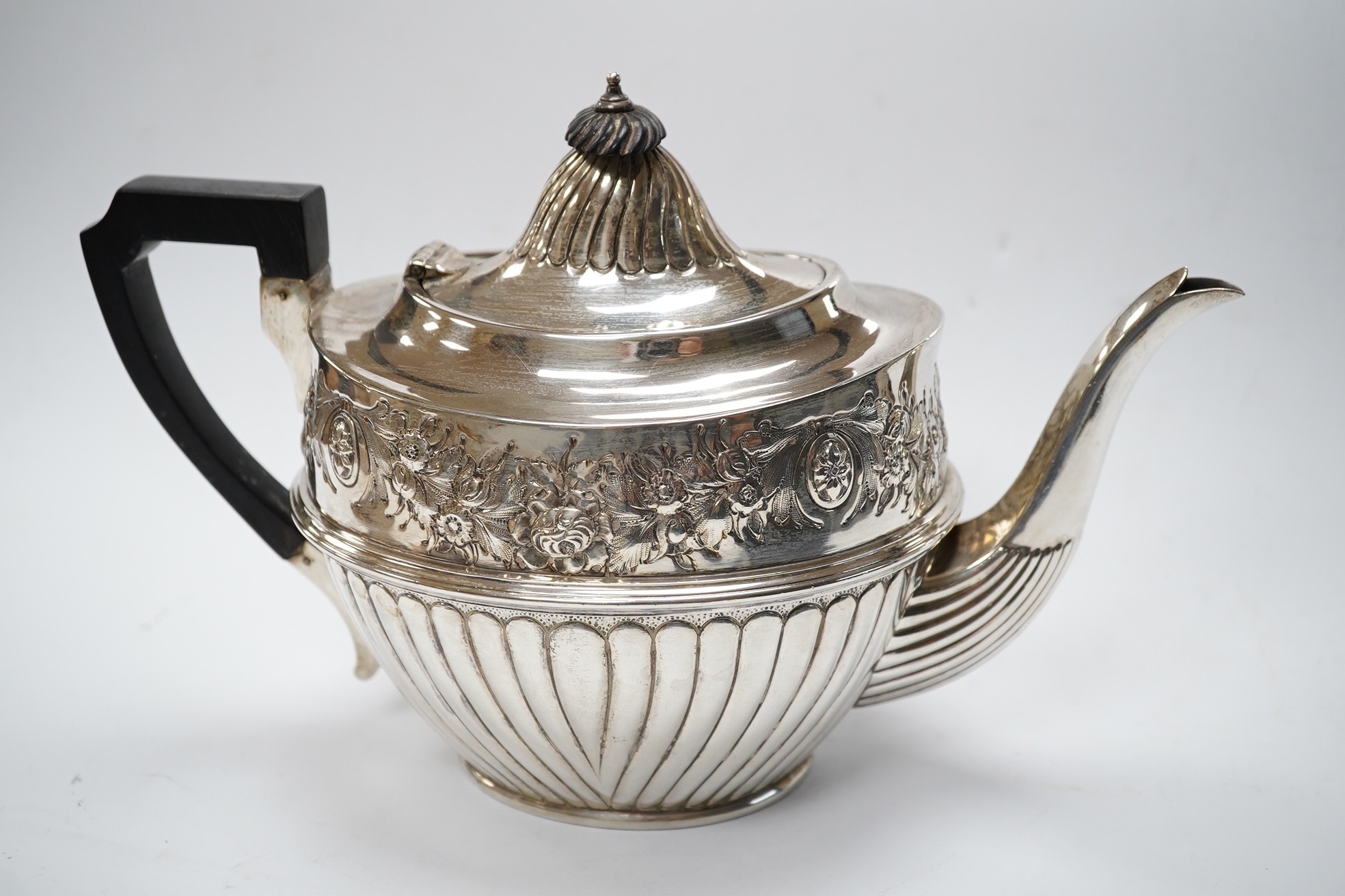 A late Victorian silver half fluted and floral embossed teapot, John Round & Sons, Sheffield, 1895, gross weight 22.8oz. Condition - poor.